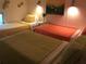 Comfortable bedroom features three beds with decorative pillows and overhead lighting fixtures at 712 Sunset Cv, Madeira Beach, FL 33708