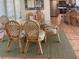 Cozy dining area featuring a glass table and wicker chairs, perfect for casual meals and gatherings at 712 Sunset Cv, Madeira Beach, FL 33708