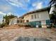 Two-story home with outdoor brick patio, gas grill, and partial water view at 712 Sunset Cv, Madeira Beach, FL 33708