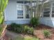 Exterior view of home with multiple windows, complemented by decorative shrubbery and mulch at 712 Sunset Cv, Madeira Beach, FL 33708