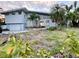 Single-Gathering home featuring a two-car garage and tropical landscaping in a residential neighborhood at 712 Sunset Cv, Madeira Beach, FL 33708