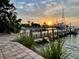 Waterfront home with private boat dock and patio with pavers under a colorful sunset at 712 Sunset Cv, Madeira Beach, FL 33708