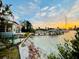 Picturesque waterfront home with a private dock, lush greenery, and serene water views at sunset at 712 Sunset Cv, Madeira Beach, FL 33708