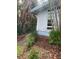 Exterior of a light blue home with lush landscaping and a pathway leading to a green fence at 712 Sunset Cv, Madeira Beach, FL 33708