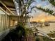 Scenic waterfront view with dock, palm trees, and a glimpse of the home's exterior at sunset at 712 Sunset Cv, Madeira Beach, FL 33708