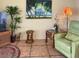 Inviting living room with a tropical painting, comfortable green chair, and stylish wicker accents at 712 Sunset Cv, Madeira Beach, FL 33708