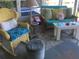 Bright patio with wicker furniture, ocean-themed decor, and pool views provides a relaxing atmosphere at 712 Sunset Cv, Madeira Beach, FL 33708