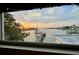 Window view capturing a scenic waterfront with a private dock and boats at sunset at 712 Sunset Cv, Madeira Beach, FL 33708