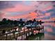 Picturesque waterfront view at sunset with a dock and boats offers serene coastal living at 712 Sunset Cv, Madeira Beach, FL 33708