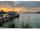 Picturesque waterfront view with a private dock, boat, and serene sunset sky at 712 Sunset Cv, Madeira Beach, FL 33708