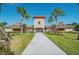 Community clubhouse features a charming walkway, complemented by palm trees and landscaping, offering a welcoming entrance at 7139 Steer Blade Dr, Zephyrhills, FL 33541
