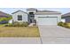 A single Gathering home with a two-car garage, a manicured lawn and stone accents at 7139 Steer Blade Dr, Zephyrhills, FL 33541