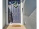 A blue front door with a wreath and a welcome mat that reads 'so happy you're here' at 7139 Steer Blade Dr, Zephyrhills, FL 33541