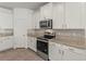A view of the kitchen with white cabinetry, stainless steel appliances and granite countertops at 7139 Steer Blade Dr, Zephyrhills, FL 33541