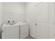 Functional laundry room with washer, dryer, shelving, and door to the rest of the house at 7139 Steer Blade Dr, Zephyrhills, FL 33541