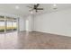 Spacious living room with tile floors and sliding glass door to outdoor patio at 7139 Steer Blade Dr, Zephyrhills, FL 33541