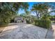 Charming single-story home with mature trees, a blue door, and a unique textured driveway at 785 5Th S St, Safety Harbor, FL 34695