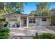 Inviting single-story home showcasing landscaping and a blue door with mature trees in a quiet neighborhood at 785 5Th S St, Safety Harbor, FL 34695