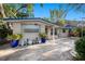 Inviting single-story home showcasing landscaping and a blue door with mature trees in a quiet neighborhood at 785 5Th S St, Safety Harbor, FL 34695