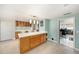 Stylish kitchen features custom wood cabinetry, backsplash, granite countertops, and an island for prep and casual dining at 785 5Th S St, Safety Harbor, FL 34695