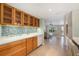 Kitchen showcases wood cabinets, glass tile backsplash, and is open to the living room with easy flow for entertaining guests at 785 5Th S St, Safety Harbor, FL 34695