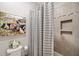 The renovated bathroom features gray tile and a striped shower curtain, complementing the artwork at 8226 Summer Brook Ct, Land O Lakes, FL 34638