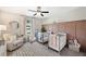 Bright Bedroom featuring two cribs, a ceiling fan, and modern decor at 8226 Summer Brook Ct, Land O Lakes, FL 34638