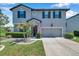 Charming two-story home boasts a gray exterior, manicured landscaping, and an attached two-car garage at 8226 Summer Brook Ct, Land O Lakes, FL 34638