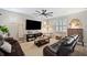Comfortable living room with wood-look floors, a ceiling fan and dark leather couches at 8226 Summer Brook Ct, Land O Lakes, FL 34638