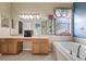 Bright bathroom featuring double sinks, a soaking tub, and neutral tile flooring at 8429 Hunters Fork Loop, Ruskin, FL 33573