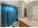 Small bathroom featuring blue shower curtain, toilet, sink, and vanity at 8429 Hunters Fork Loop, Ruskin, FL 33573