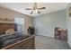 Relaxing bedroom with blue accent wall, bed, ceiling fan and dark furnishings at 8429 Hunters Fork Loop, Ruskin, FL 33573