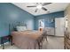Cozy bedroom with blue walls, an iron bed frame, and a ceiling fan at 8429 Hunters Fork Loop, Ruskin, FL 33573