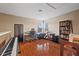 Bright bedroom featuring hardwood floors, a desk, and a grand piano at 8429 Hunters Fork Loop, Ruskin, FL 33573