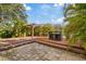 A multi-level wooden deck and brick patio are surrounded by lush tropical landscaping at 8429 Hunters Fork Loop, Ruskin, FL 33573