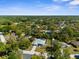 Aerial view of a home with screened-in pool and lush landscaping surrounded by mature trees at 8604 Vicksburg Rd, Spring Hill, FL 34608
