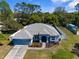 A captivating aerial view of this home's fresh roof, lush landscaping, and welcoming facade at 8604 Vicksburg Rd, Spring Hill, FL 34608
