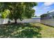 Large backyard with mature tree providing shade, a privacy fence, and lawn at 8604 Vicksburg Rd, Spring Hill, FL 34608