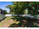 Backyard featuring mature trees, privacy fence, grass lawn, and screened in patio at 8604 Vicksburg Rd, Spring Hill, FL 34608