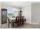 Bright dining room with a window view, set for six, complemented by classic display cabinets at 8604 Vicksburg Rd, Spring Hill, FL 34608