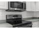 Close up of a well-maintained kitchen features stainless steel appliances and a white backsplash at 8604 Vicksburg Rd, Spring Hill, FL 34608