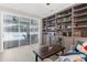 Living room features a view of the pool area through vertical blinds and custom bookshelves at 8604 Vicksburg Rd, Spring Hill, FL 34608