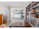 Living room showcasing vertical blinds and access to a pool area, complemented by custom bookshelves at 8604 Vicksburg Rd, Spring Hill, FL 34608