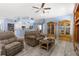 Inviting living room with wood-look floors, ceiling fan and view to the kitchen at 8604 Vicksburg Rd, Spring Hill, FL 34608