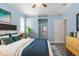 Comfortable bedroom featuring calming blue walls, ceiling fan, and a plush bed with tasteful décor at 8604 Vicksburg Rd, Spring Hill, FL 34608