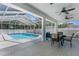 Covered patio with furniture overlooking a refreshing screened-in swimming pool, ceiling fans, and brick pavers at 8604 Vicksburg Rd, Spring Hill, FL 34608