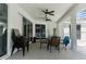 Covered pool patio with ceiling fans, brick pavers, table and chairs, and extra chairs stacked on the side at 8604 Vicksburg Rd, Spring Hill, FL 34608