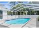Inviting screened-in pool with handrail and a concrete deck is ready for some fun in the sun at 8604 Vicksburg Rd, Spring Hill, FL 34608