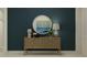 Stylish entryway featuring a decorative table with lamps and a round mirror against a blue wall at 9368 Gladsome Dr, Land O Lakes, FL 34637