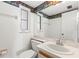 Cozy bathroom with decorative wallpaper border, white cabinets, and vanity mirror at 9901 1St E St # D, Treasure Island, FL 33706